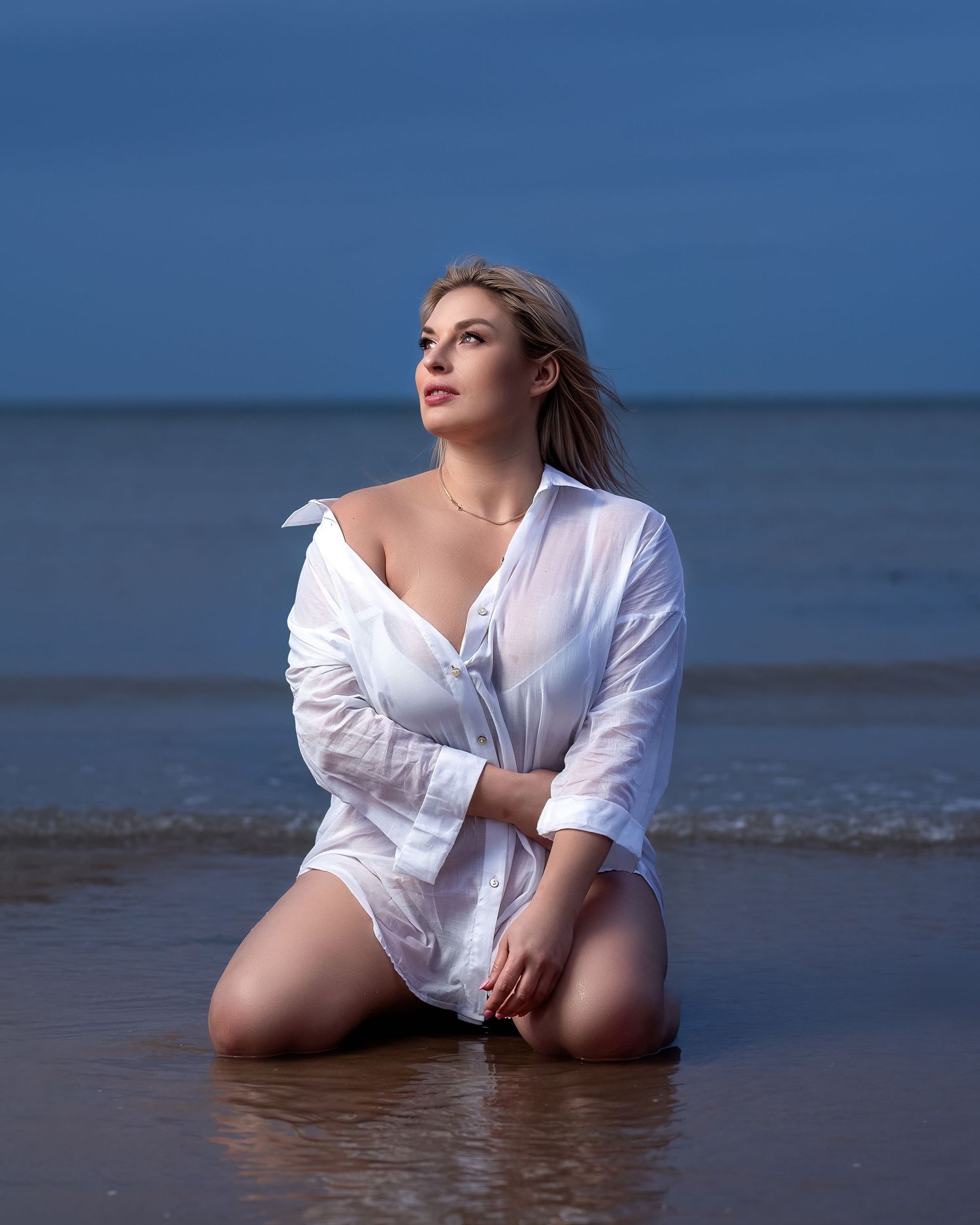 Outdoor portrait photography in Gravesend Kent with woman posing in water at the beach during sunset