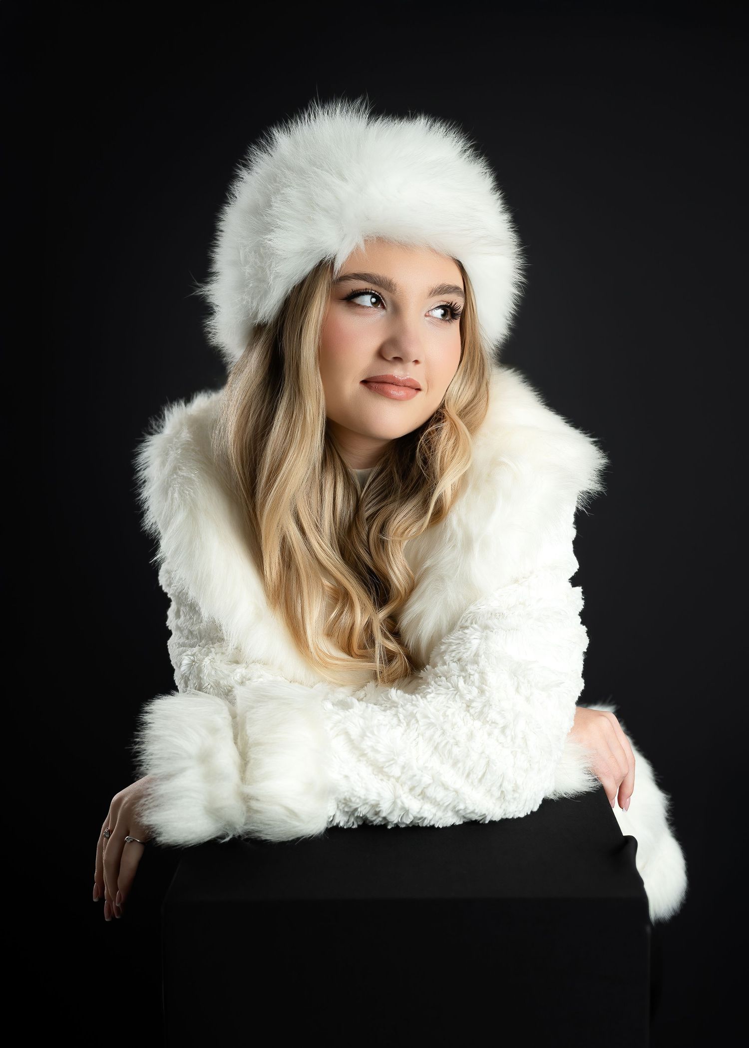 Portrait photography in Gravesend Kent with woman wearing white winter hat on dark studio background
