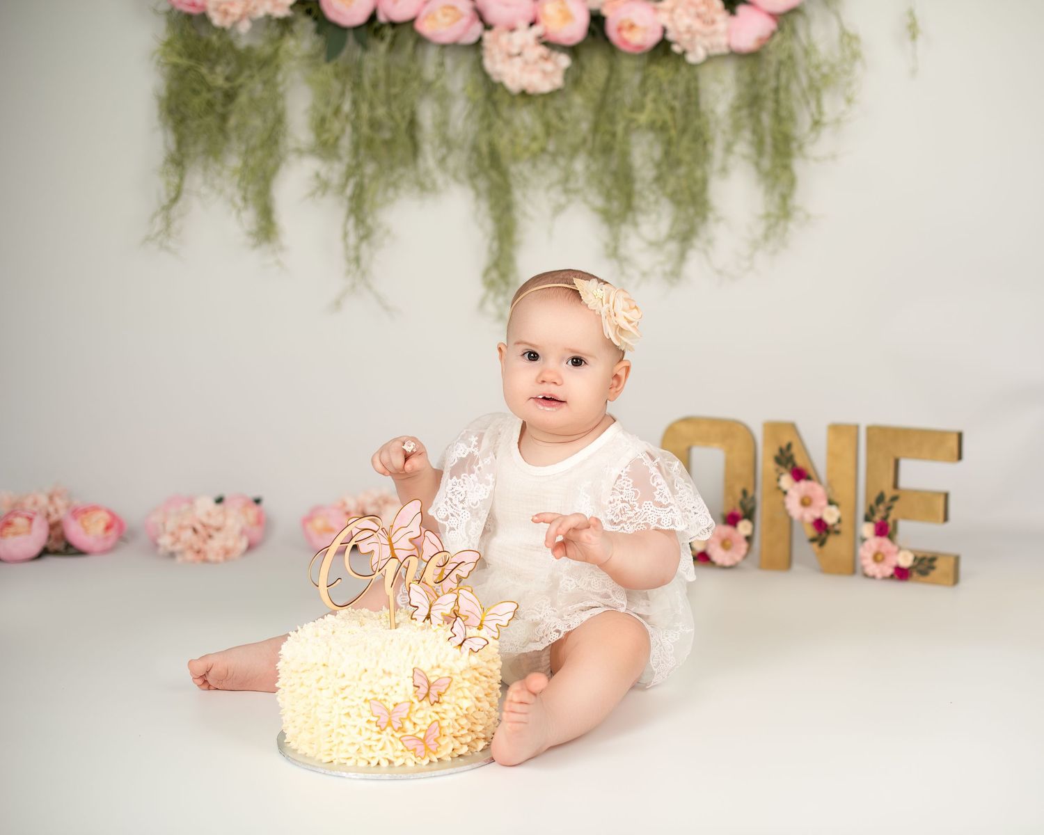 Cake smash photography in Gravesend Kent with baby celebrating first birthday with cake and floral setup