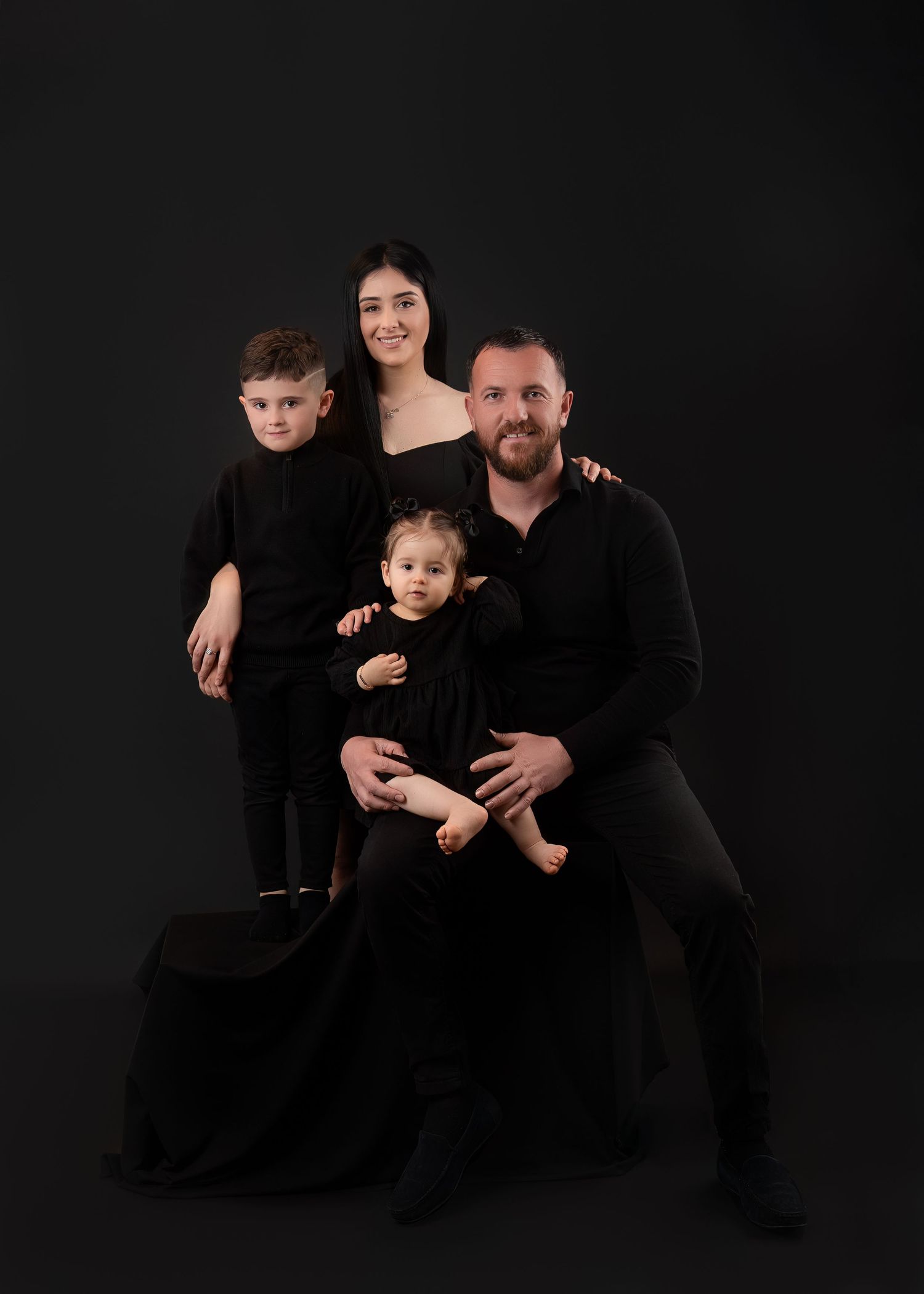 Family photography session in Gravesend Kent with parents and children in studio with black background