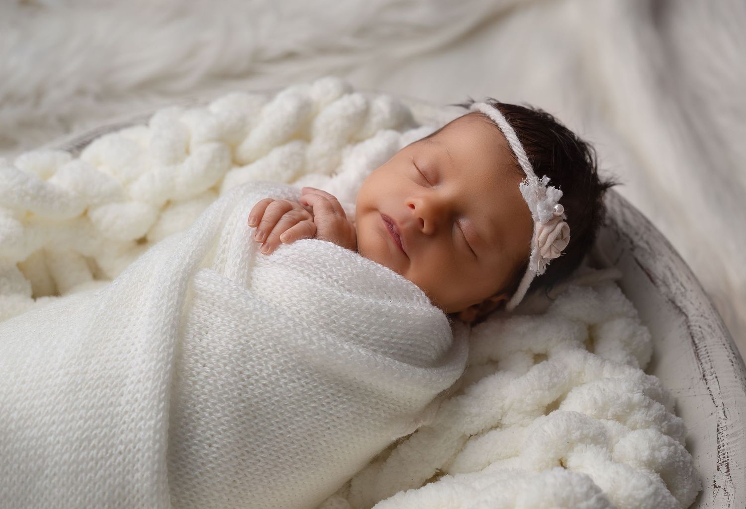 Newborn photography in Gravesend Kent with baby wrapped in white blanket sleeping close up portrait