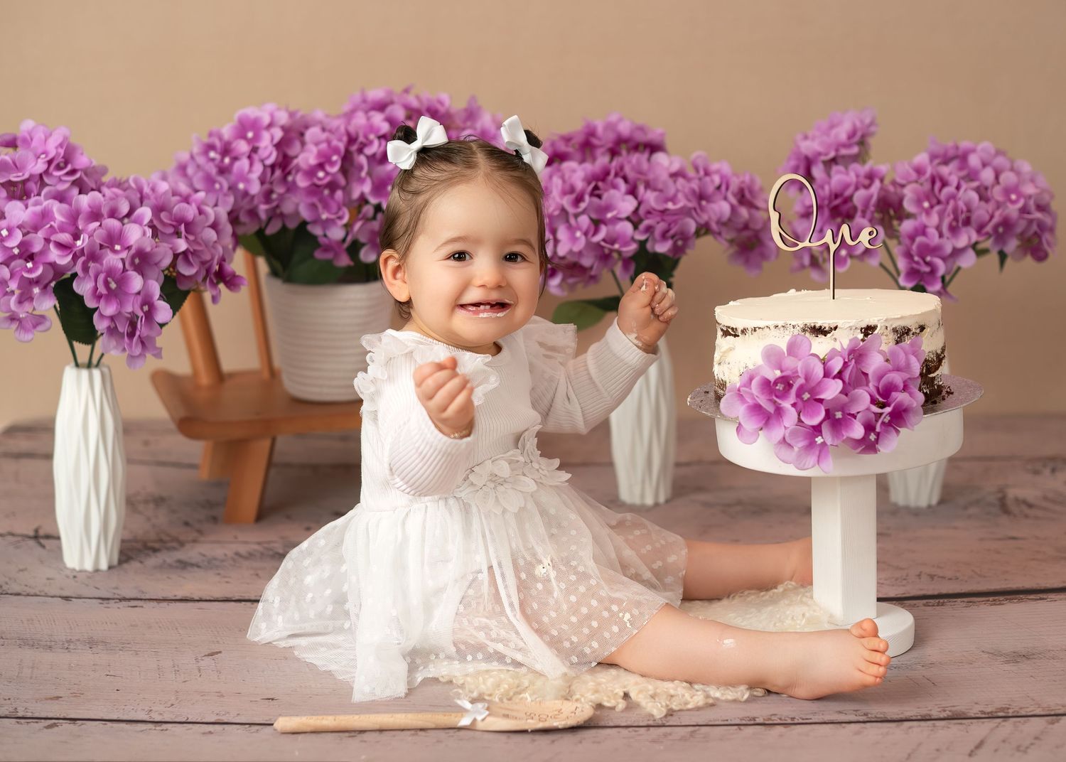 Children photography session in Gravesend Kent with baby girl sitting with purple flowers in studio