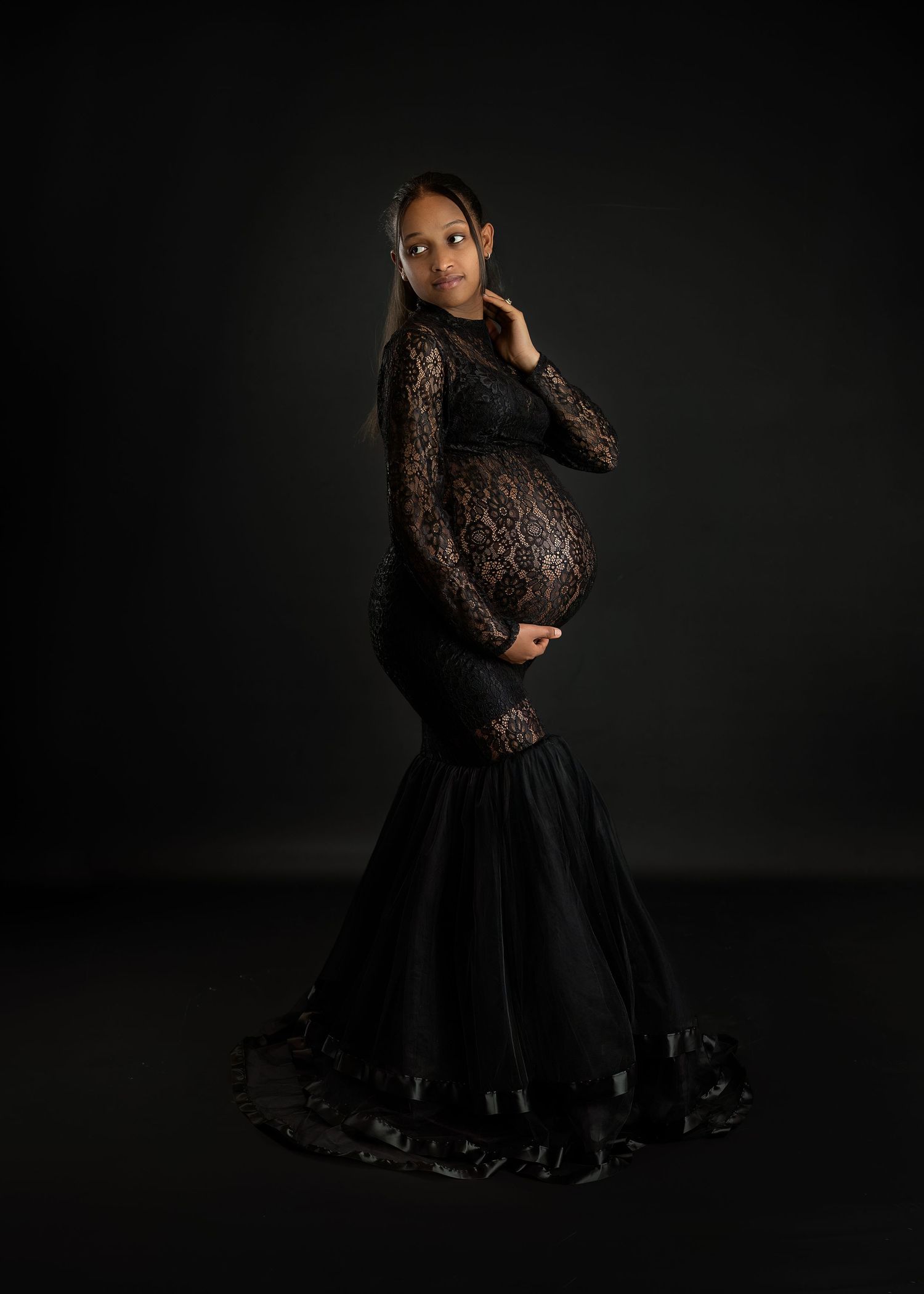 Maternity photoshoot in Gravesend Kent with pregnant woman in black dress on dark background