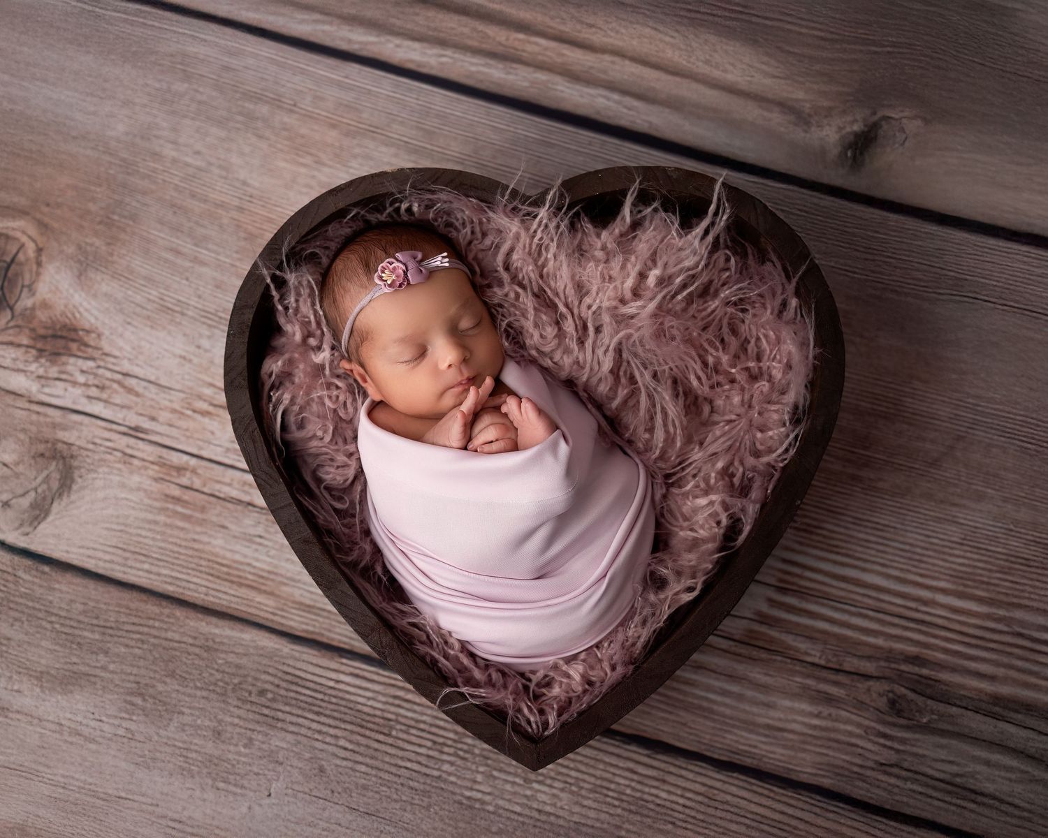 Newborn photography session in Gravesend Kent with baby wrapped in blanket inside heart shaped prop