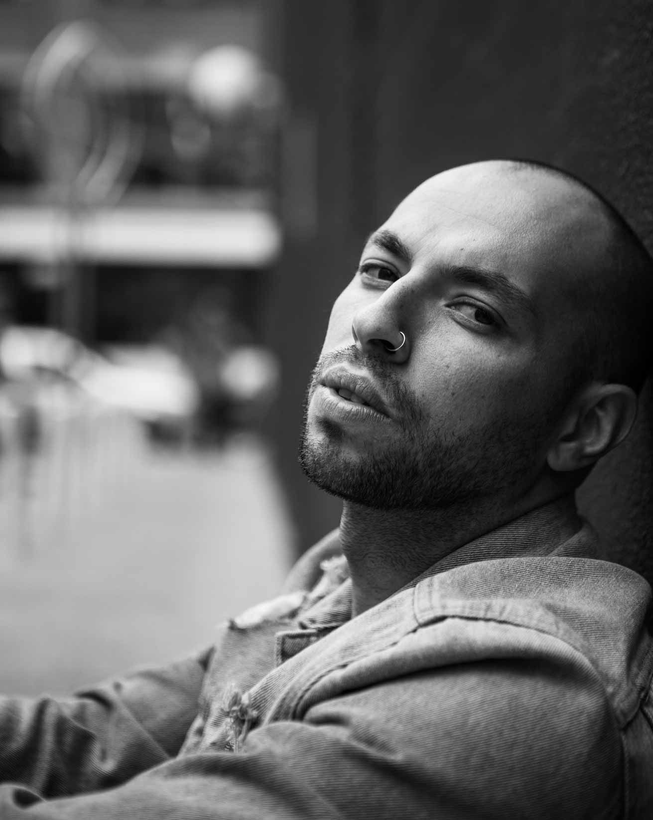 Creative black and white portrait photography with dramatic upward angle and urban background bokeh