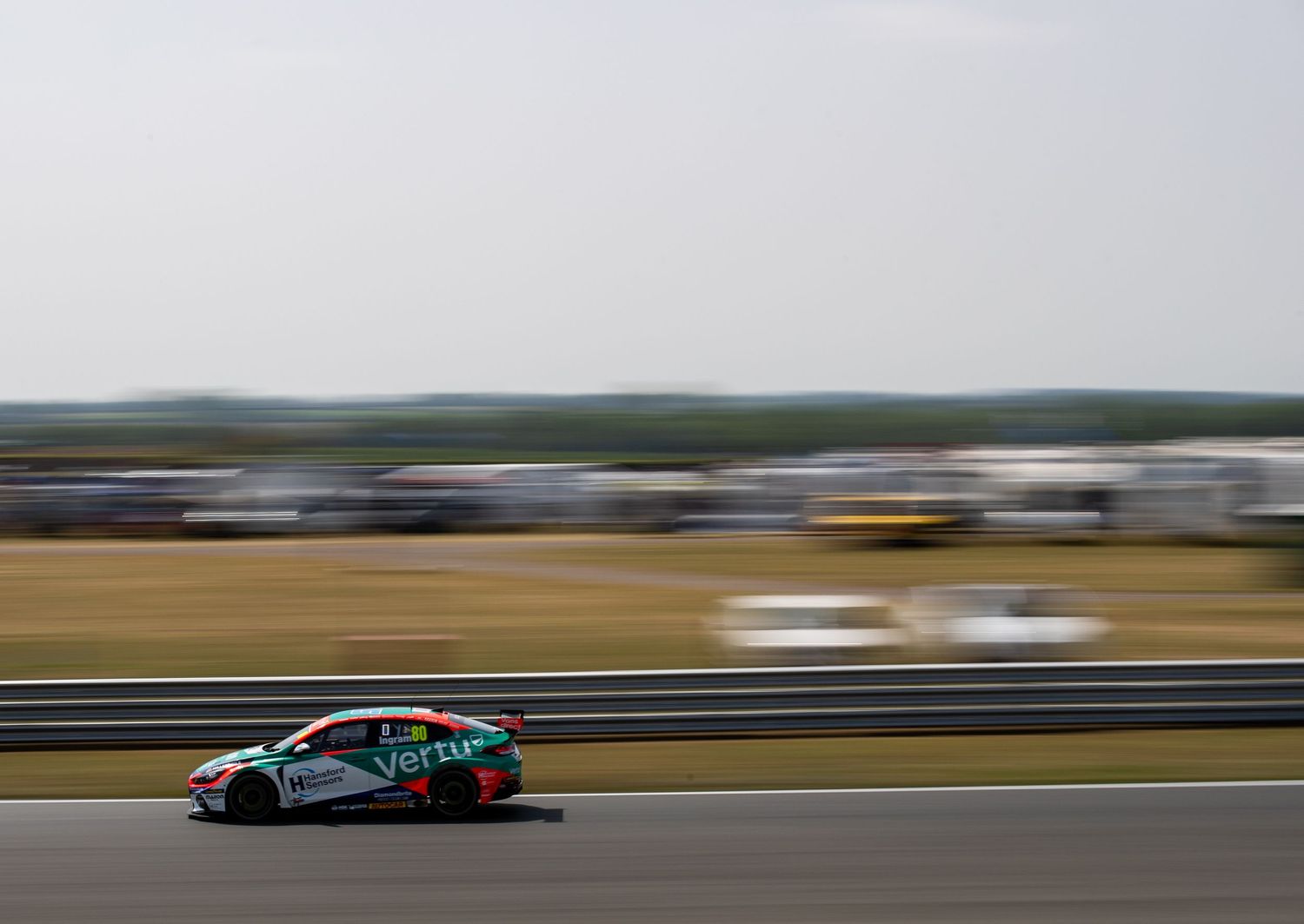 Vertu Motors BTCC Honda Civic Type R racing at speed on a flat open circuit.