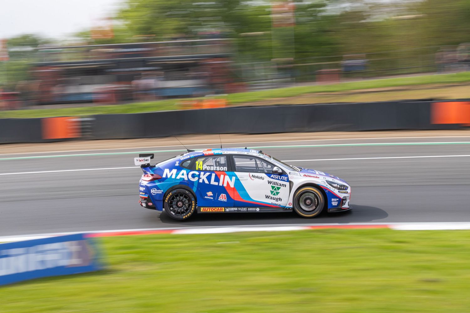 Macklin Motors BTCC touring car racing at speed on a circuit with motion blur background.