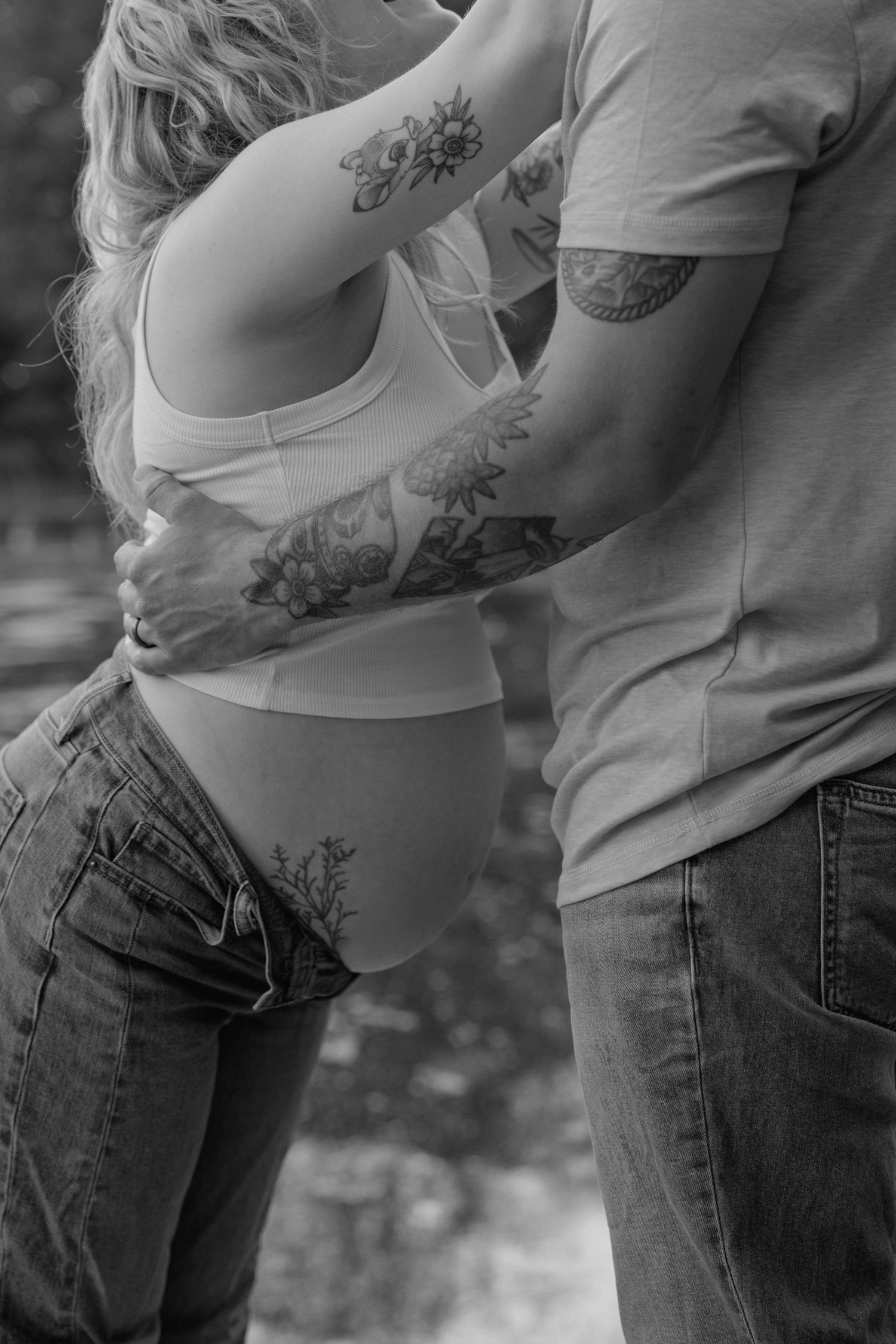 Close-up of a pregnant woman's belly while hugging her partner