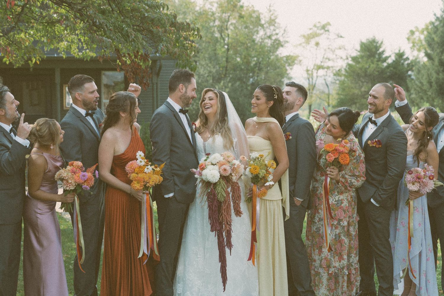 Bridal party smiling and looking at the bride and groom