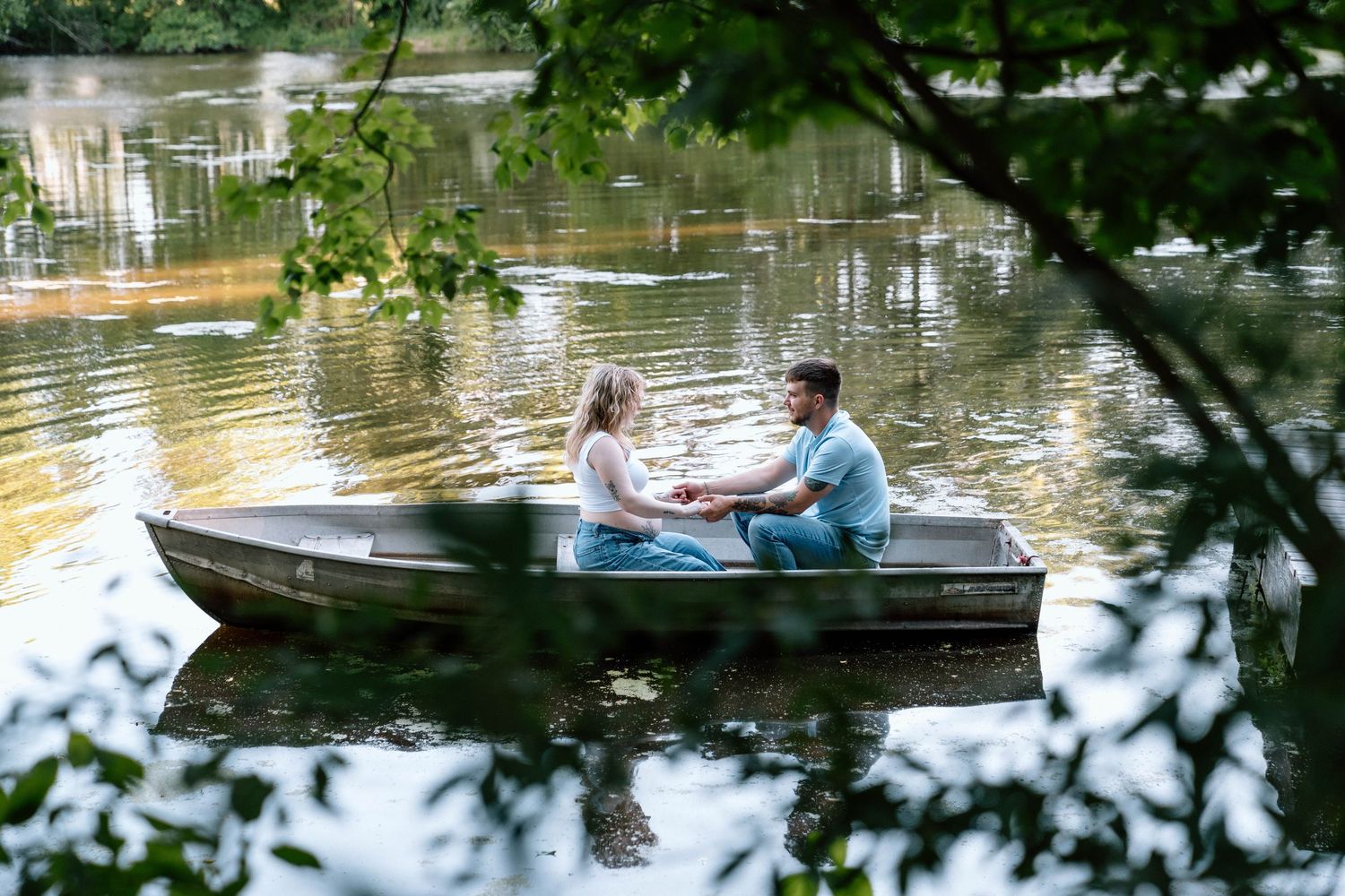 A couple holding hands on a boat in a lake