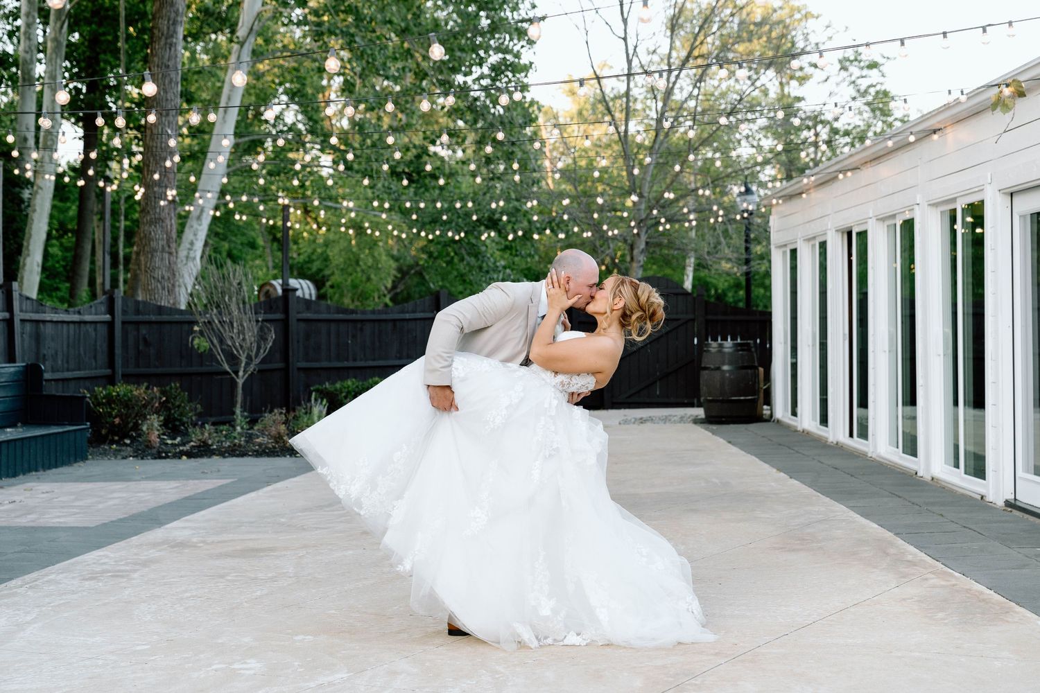 Bride and groom kissing under lights on a terrace