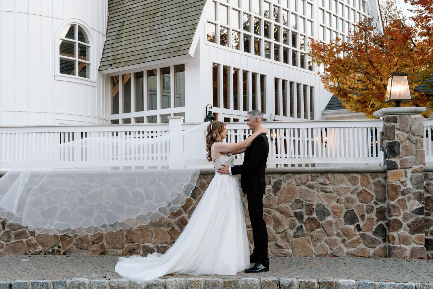 Bride and groom embracing with the bride's veil cascading behind her