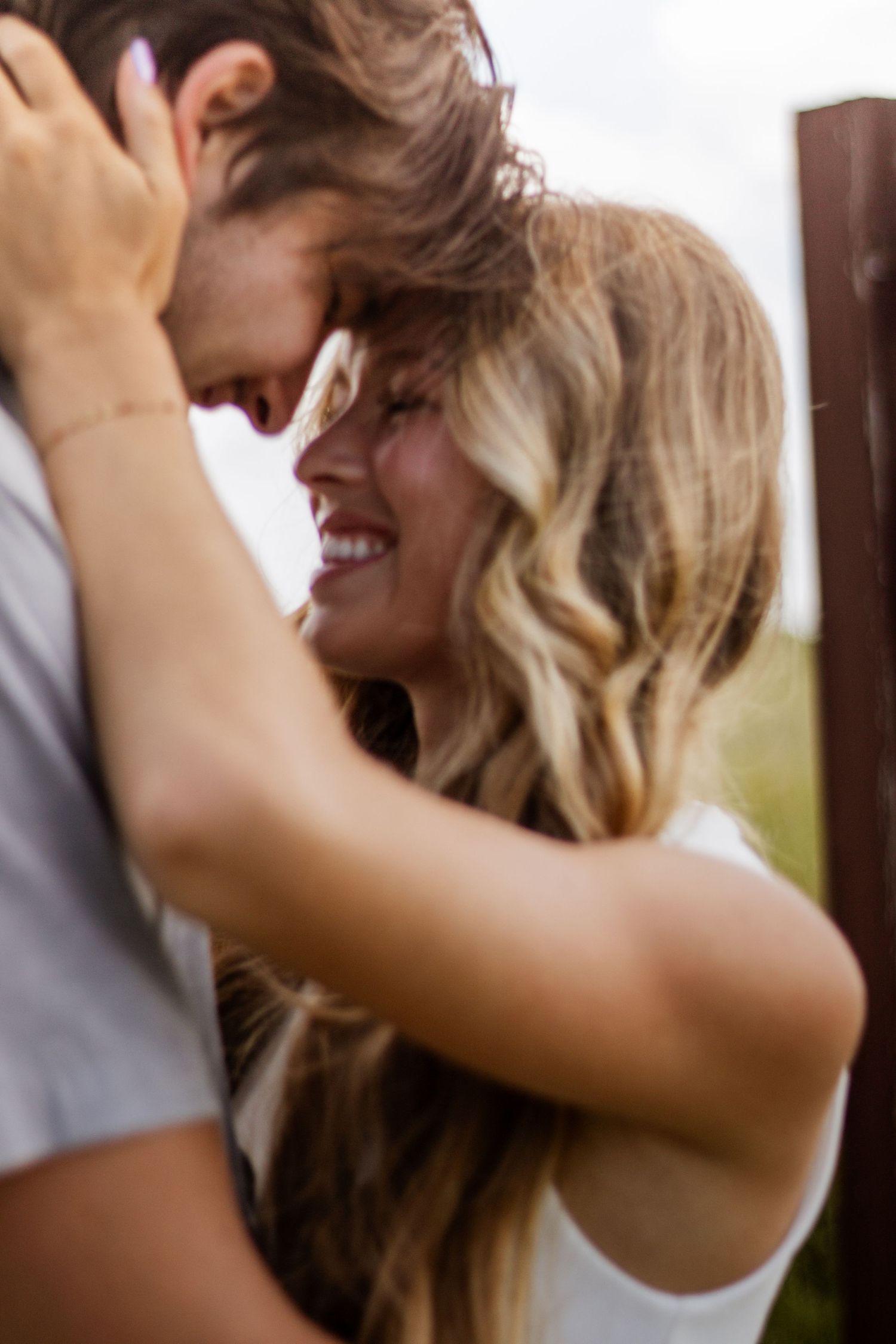 Happy couple with foreheads touching, smiling and embracing in a tender romantic outdoor moment.