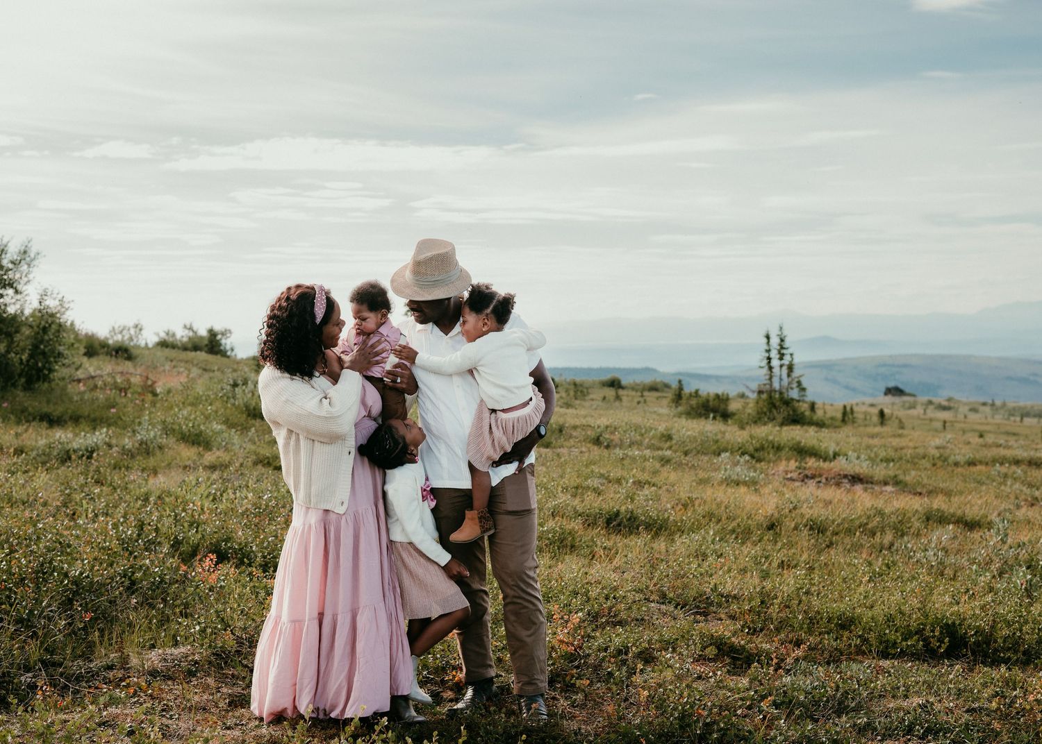 Family walking together through a grassy field during an outdoor family photography session