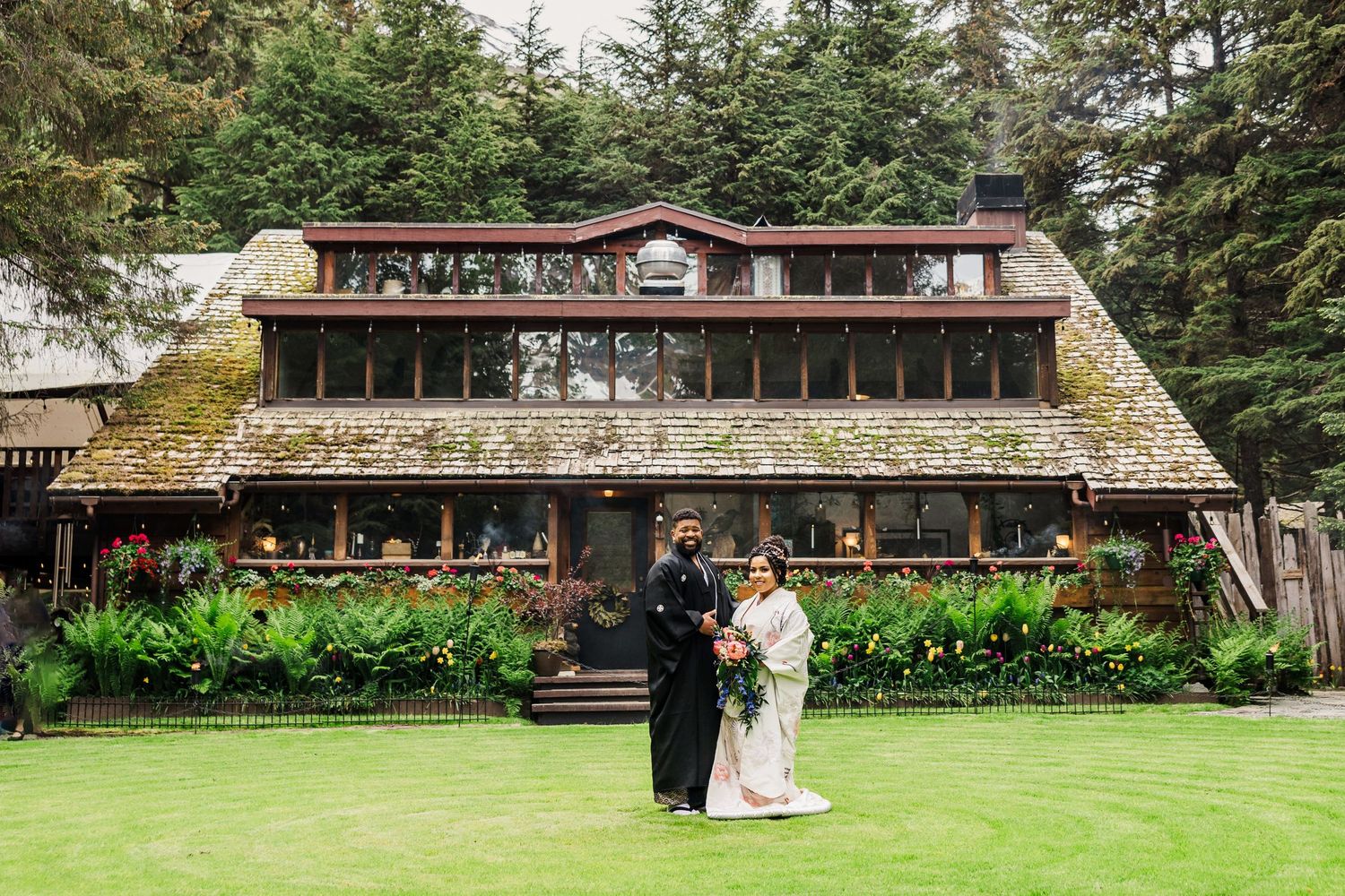 Rustic lodge wedding venue with stone facade nestled among evergreen trees.