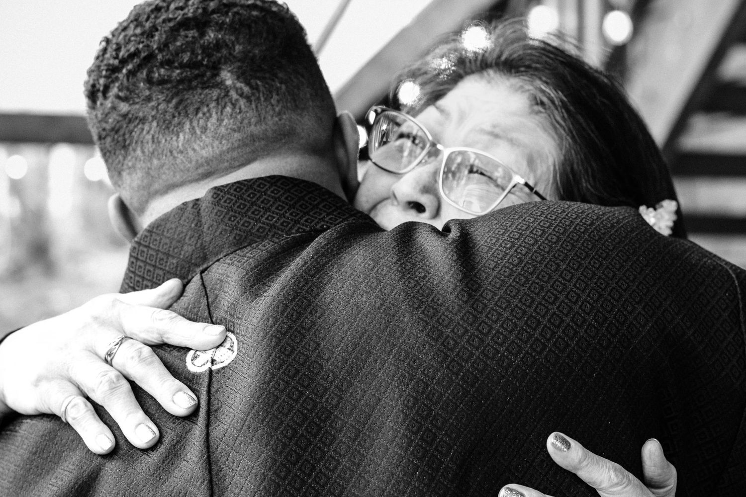 Close up of emotional embrace during intimate wedding celebration.
