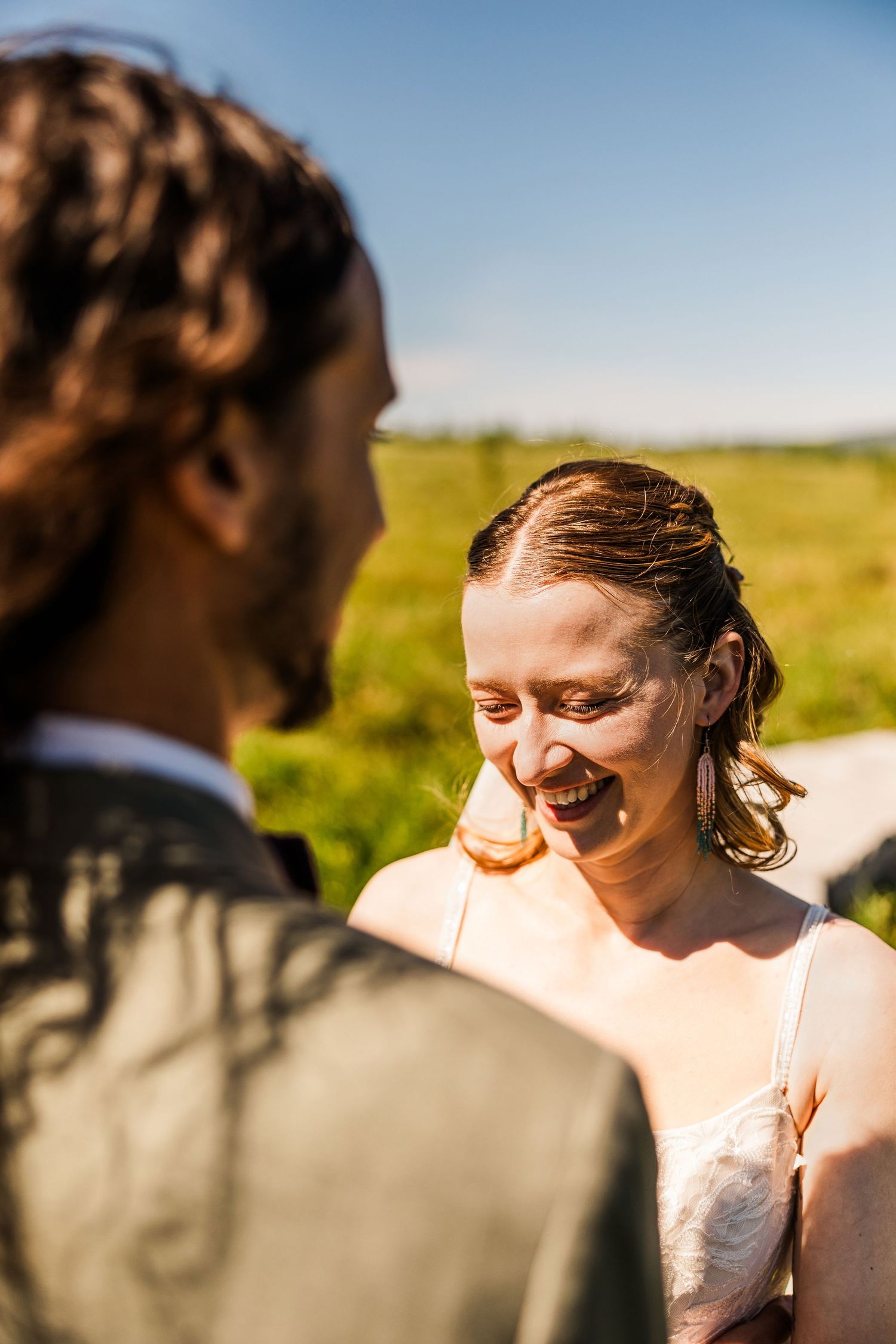 Candid moment between couple during outdoor mountain wedding ceremony.