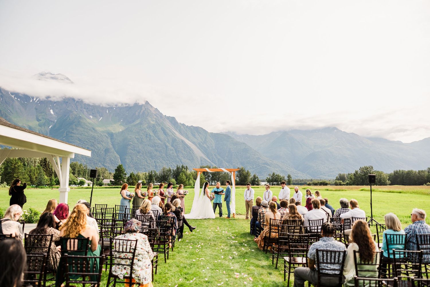 Outdoor wedding ceremony setup with mountain views and rows of chairs.