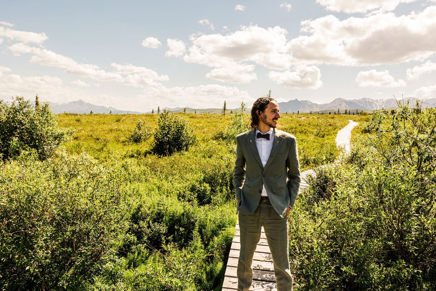 Wedding portraits captured in golden sunlight with mountain range in distance.