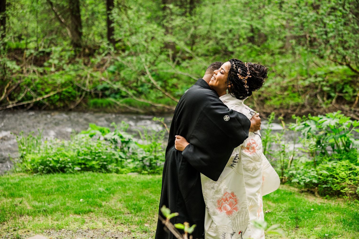 Couple embraces during intimate forest wedding ceremony wearing traditional Japanese attire.