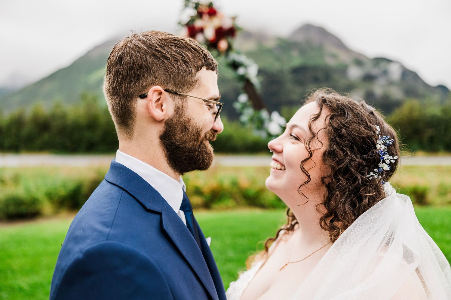 Intimate moment between newlyweds with mountain scenery behind them.
