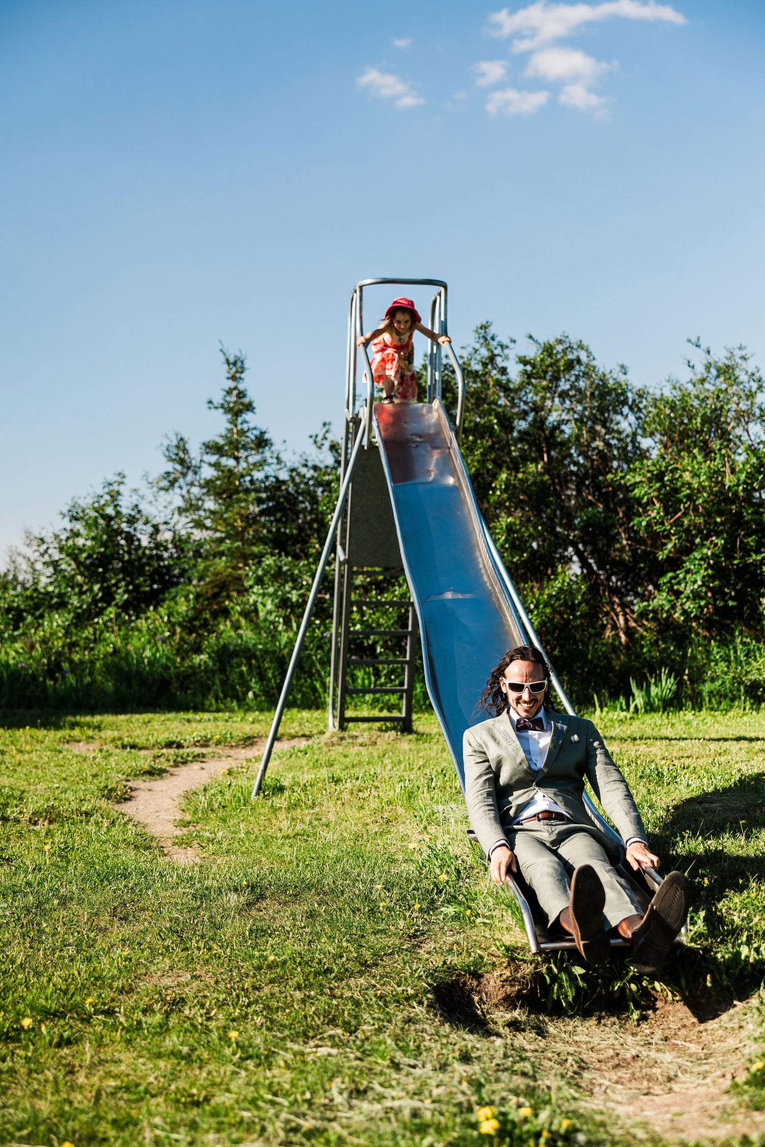 Playful moments on a playground slide in a sunny garden setting.