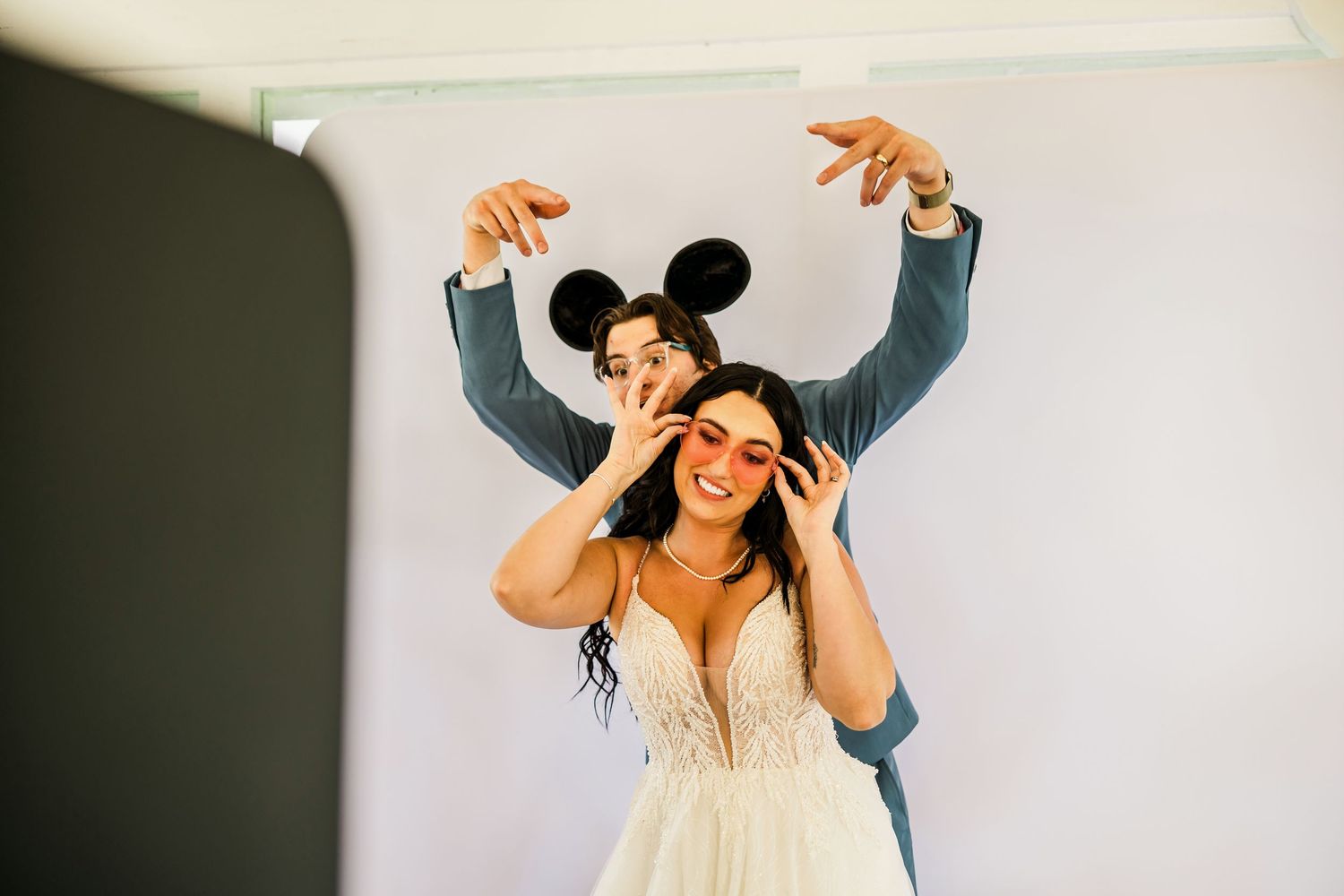 A playful moment captured during wedding preparations with Mickey Mouse ears.