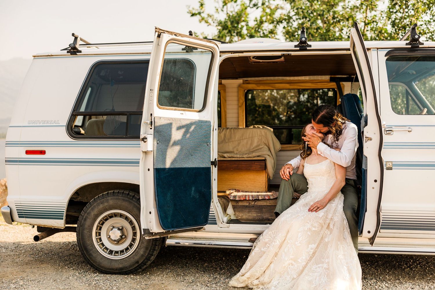 A romantic moment captured between newlyweds inside a classic white van.
