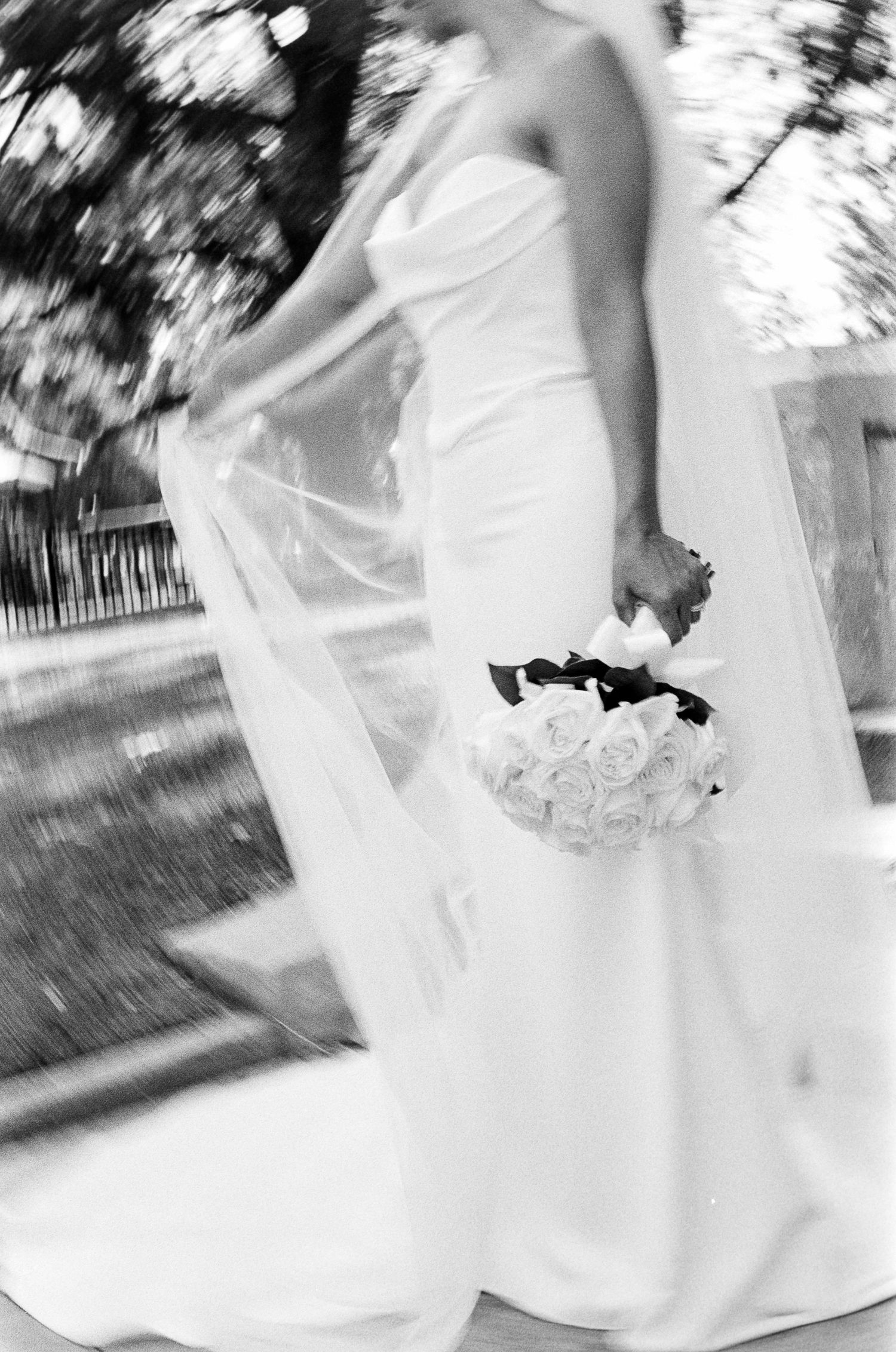Black and white film wedding photo of a bride in a strapless gown holding a rose bouquet at the Monrovia Historical Museum.