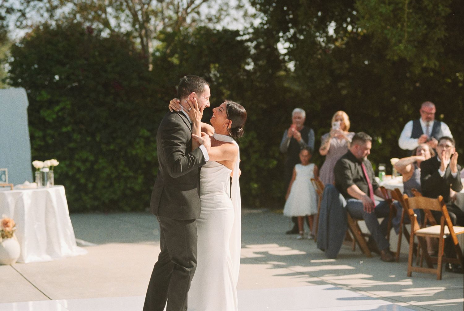 A bride and groom sharing their first dance outdoors at the Monrovia Historical Museum wedding venue.
