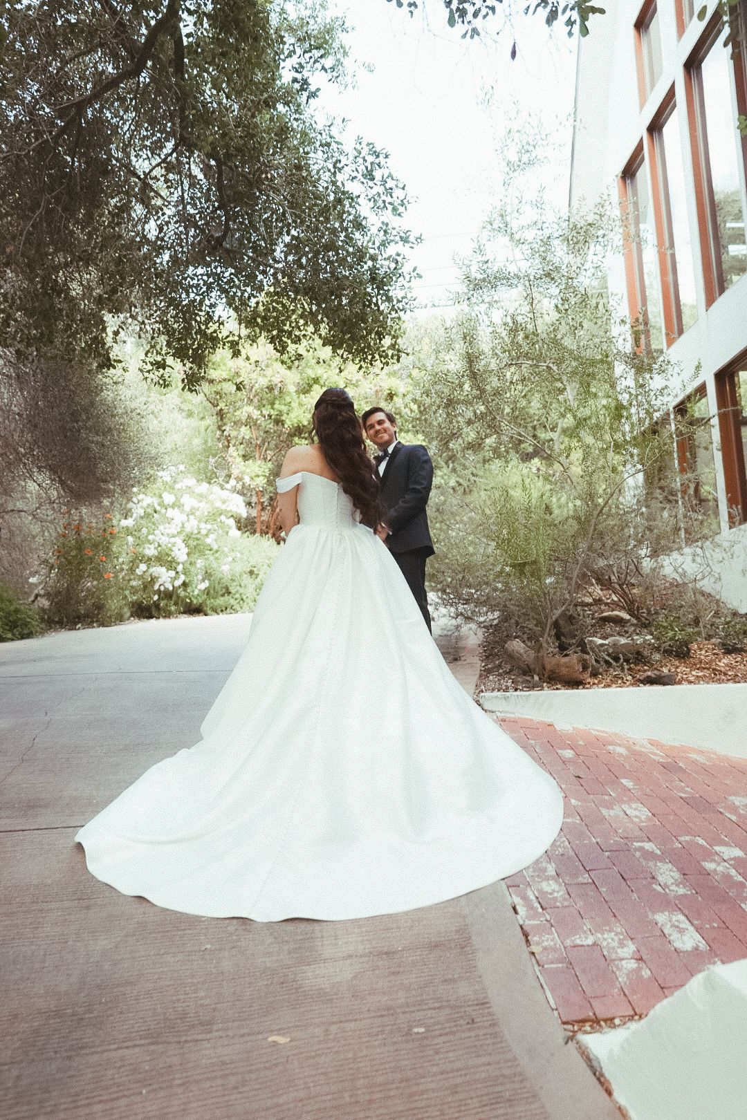 A groom smiling at his bride under the trees for their first look at a topanga canyon wedding photography session.