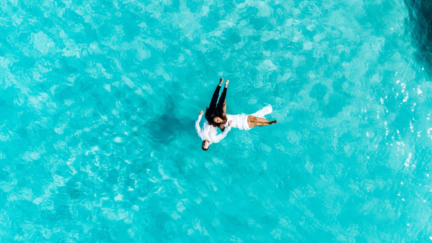 A sequence of aerial photos showing a surfer riding a bright blue ocean wave from start to finish.