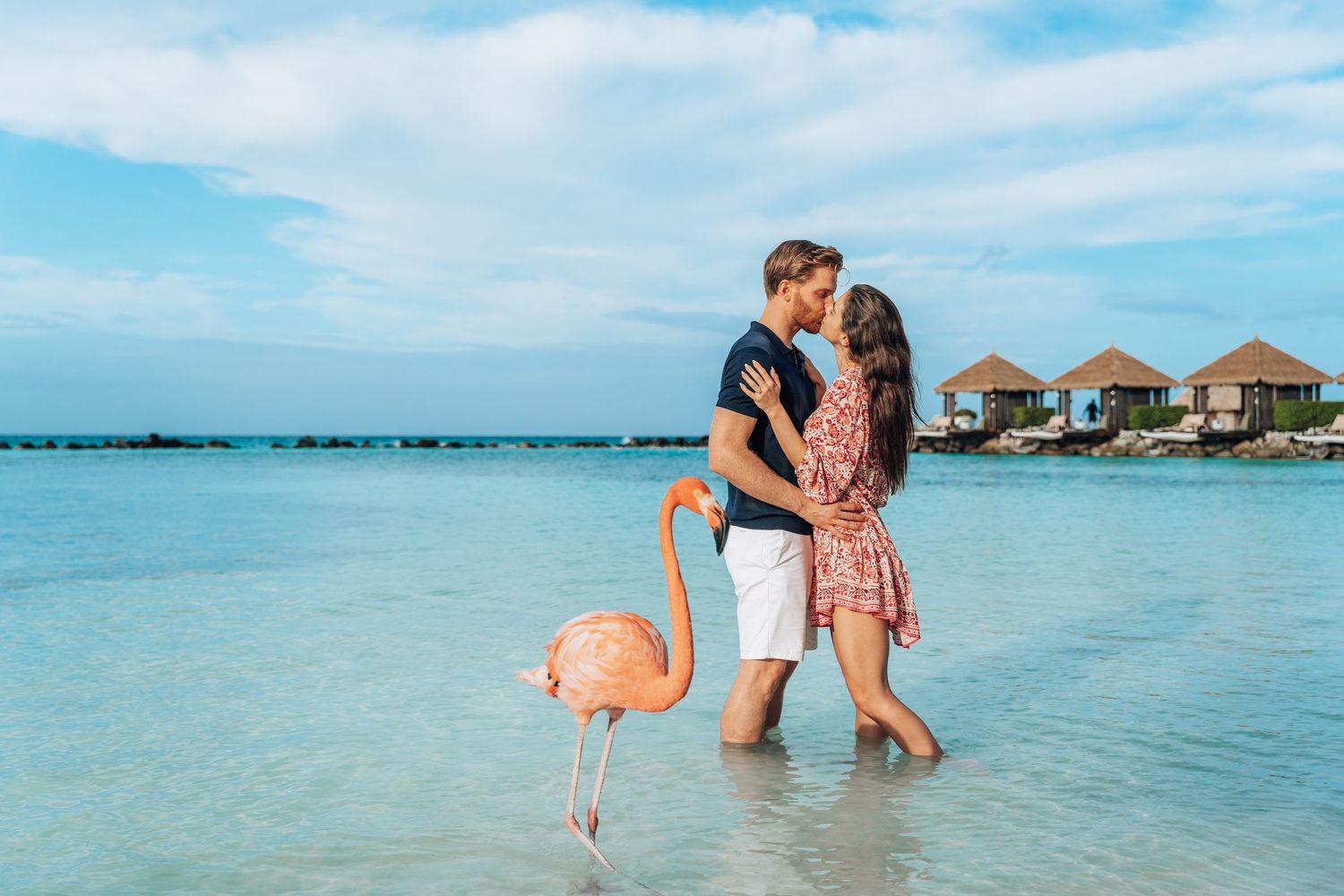 Romantic couple shares a tender moment in crystal clear turquoise waters of a tropical beach paradise.