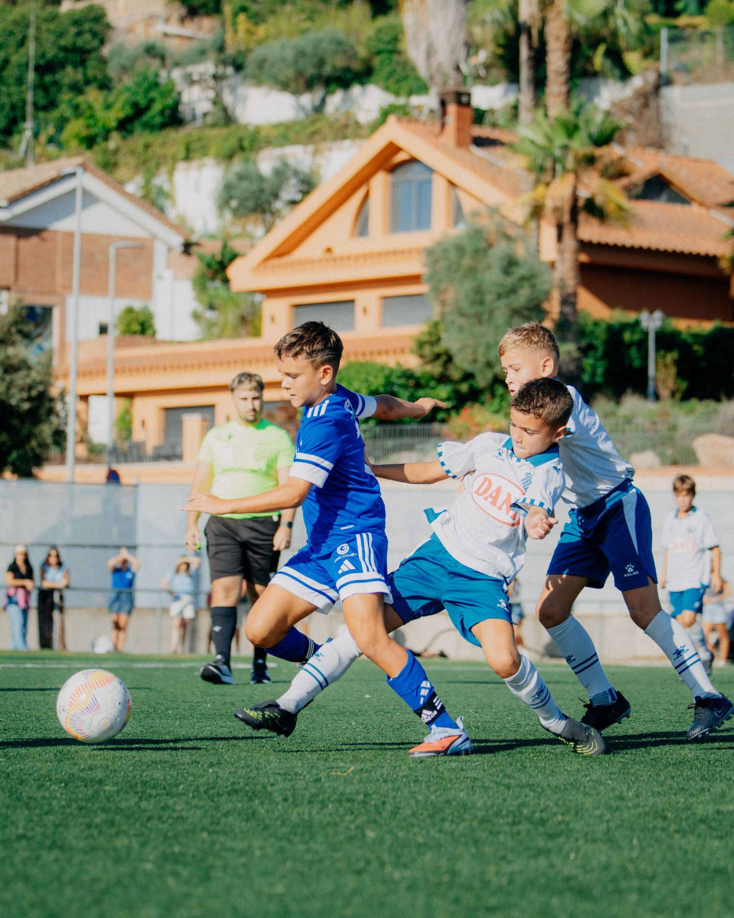 Youth soccer players compete for the ball during an intense match on a green field.