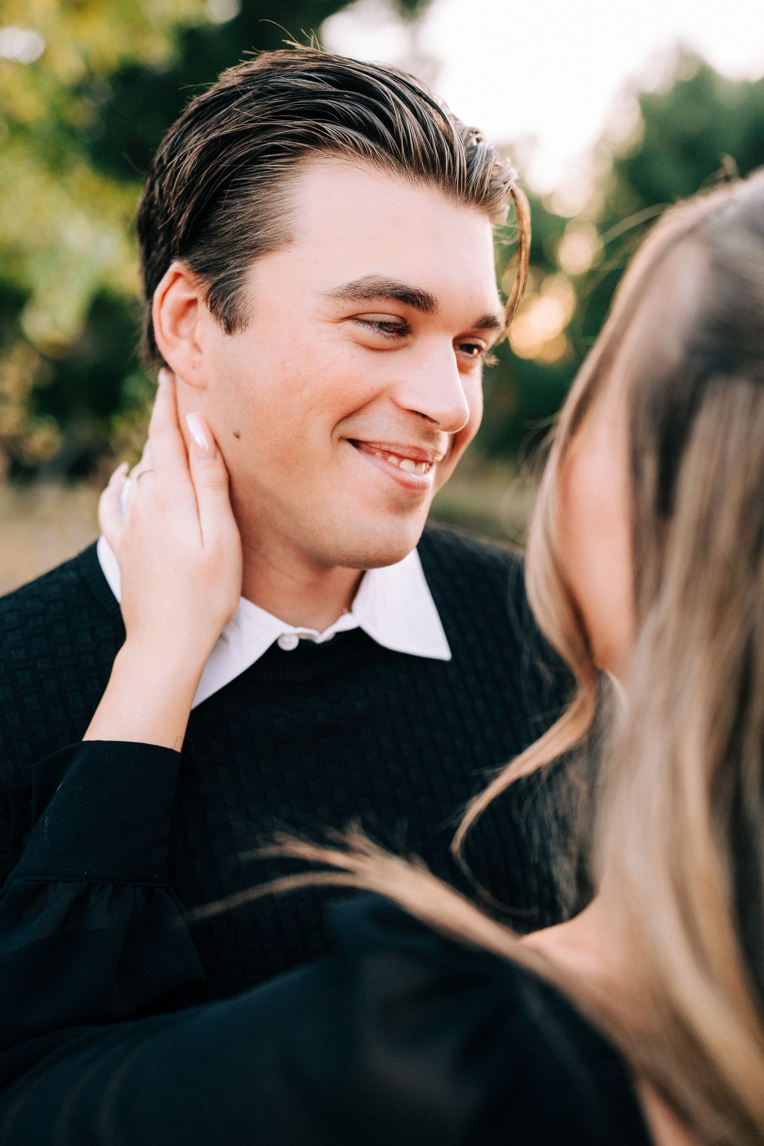 An intimate close-up portrait capturing a tender moment between a couple in the outdoor setting.