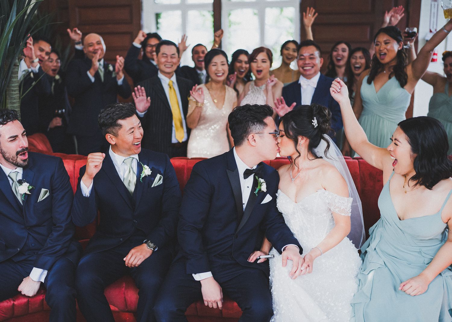 Wedding reception candid moments showing guests laughing and celebrating in an elegant indoor venue.