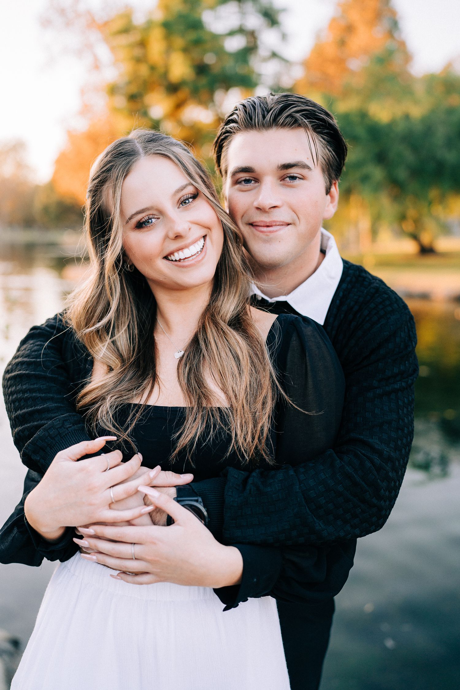 Playful engagement portrait series showing couple laughing and hugging against fall foliage backdrop.