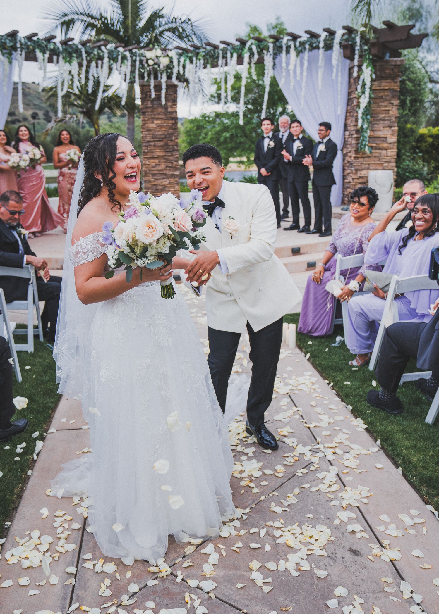 A joyful wedding ceremony procession captured in a series of photos with lavender-dressed bridesmaids and scattered flower petals.