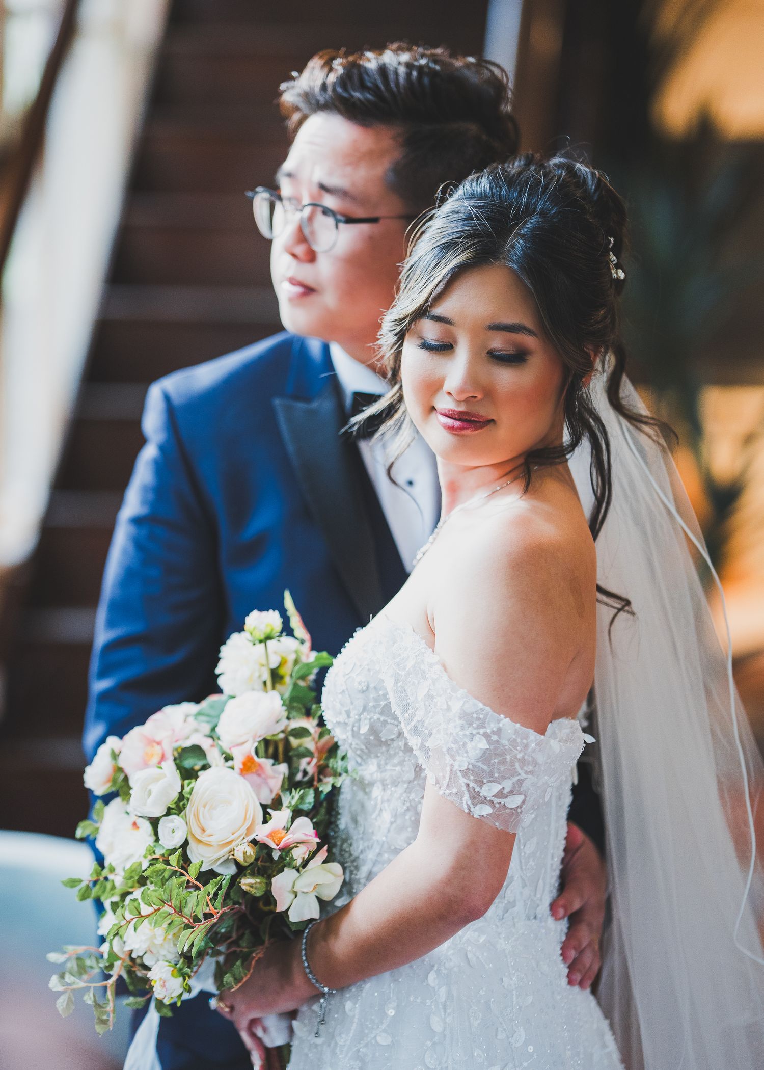 Close-up sequence of a bride in a lace wedding dress holding a white and green floral bouquet.