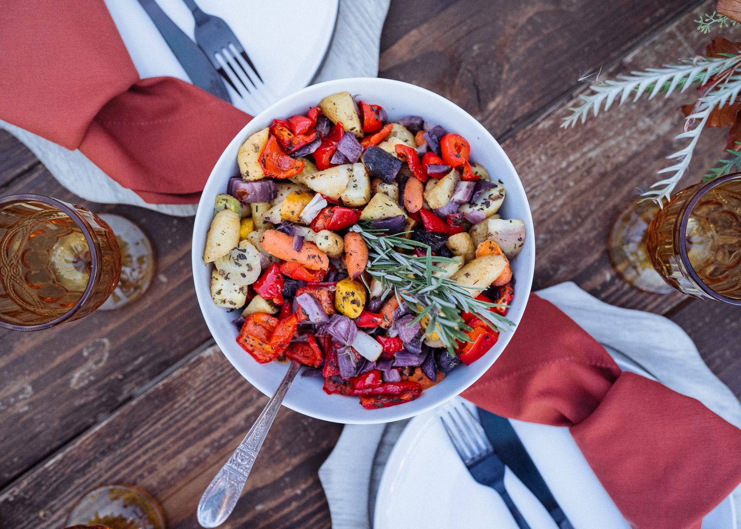 Fresh Mediterranean salad with grilled vegetables, berries and herbs served in white bowl on rustic wooden table.