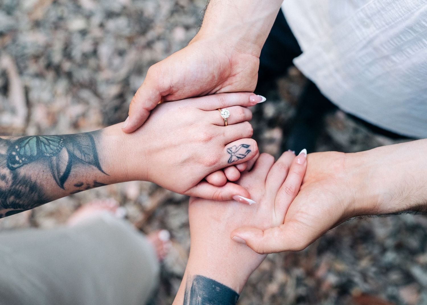 Close-up shot of hands reaching out and coming together in the woods.