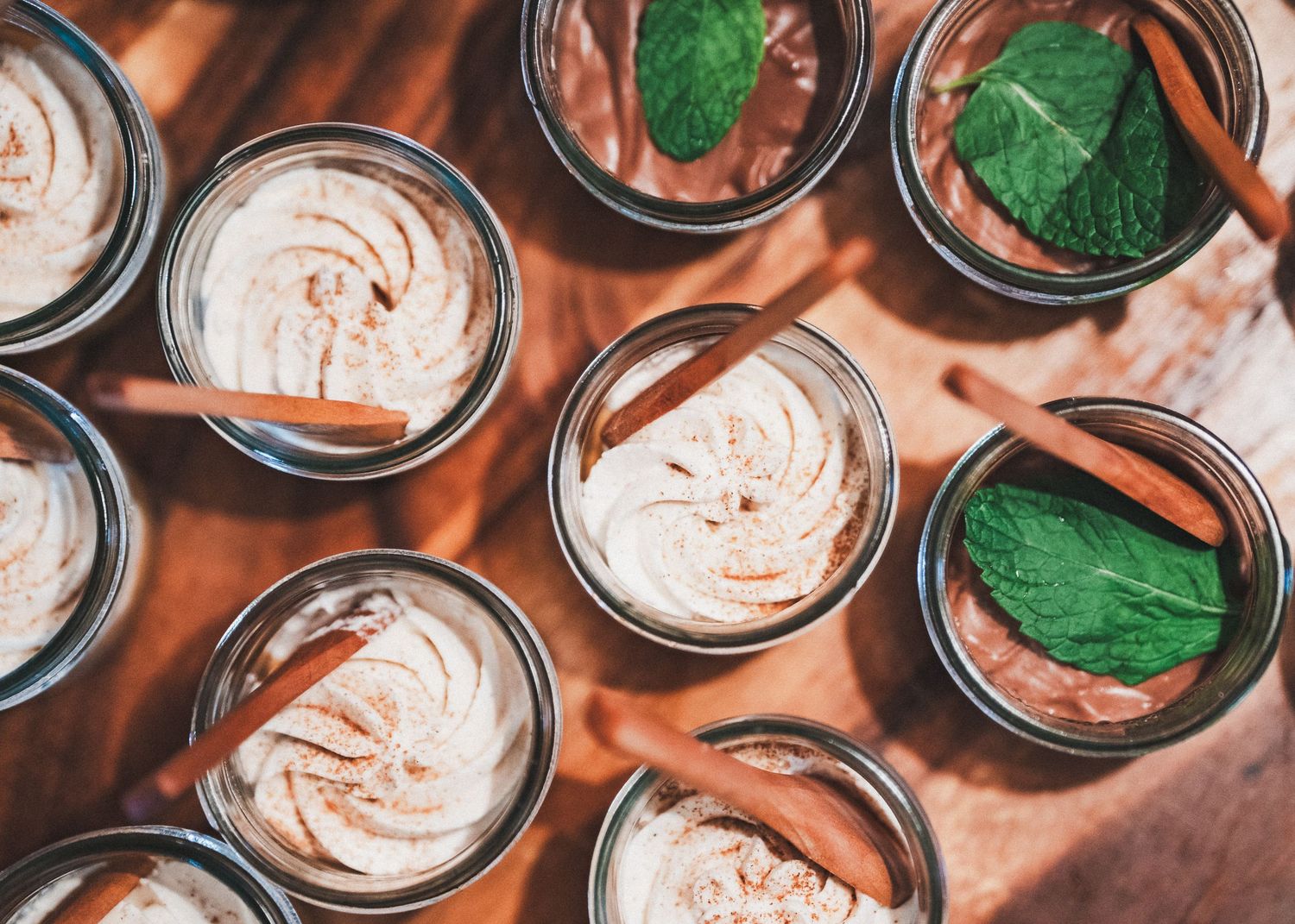 Overhead view of mason jars filled with pink whipped dessert and garnished with fresh mint leaves.