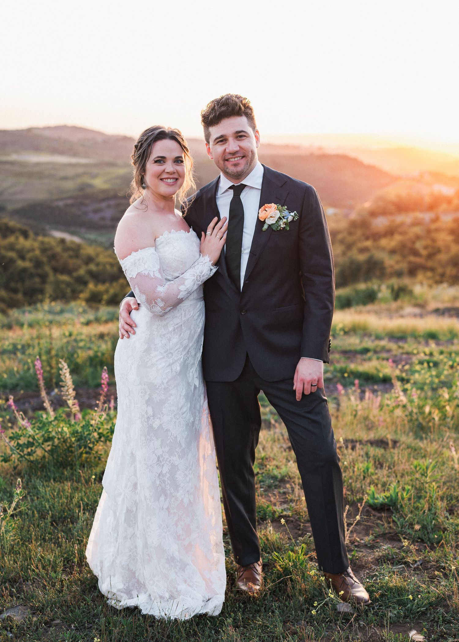 A couple poses for sunset wedding photos in a scenic mountain landscape.