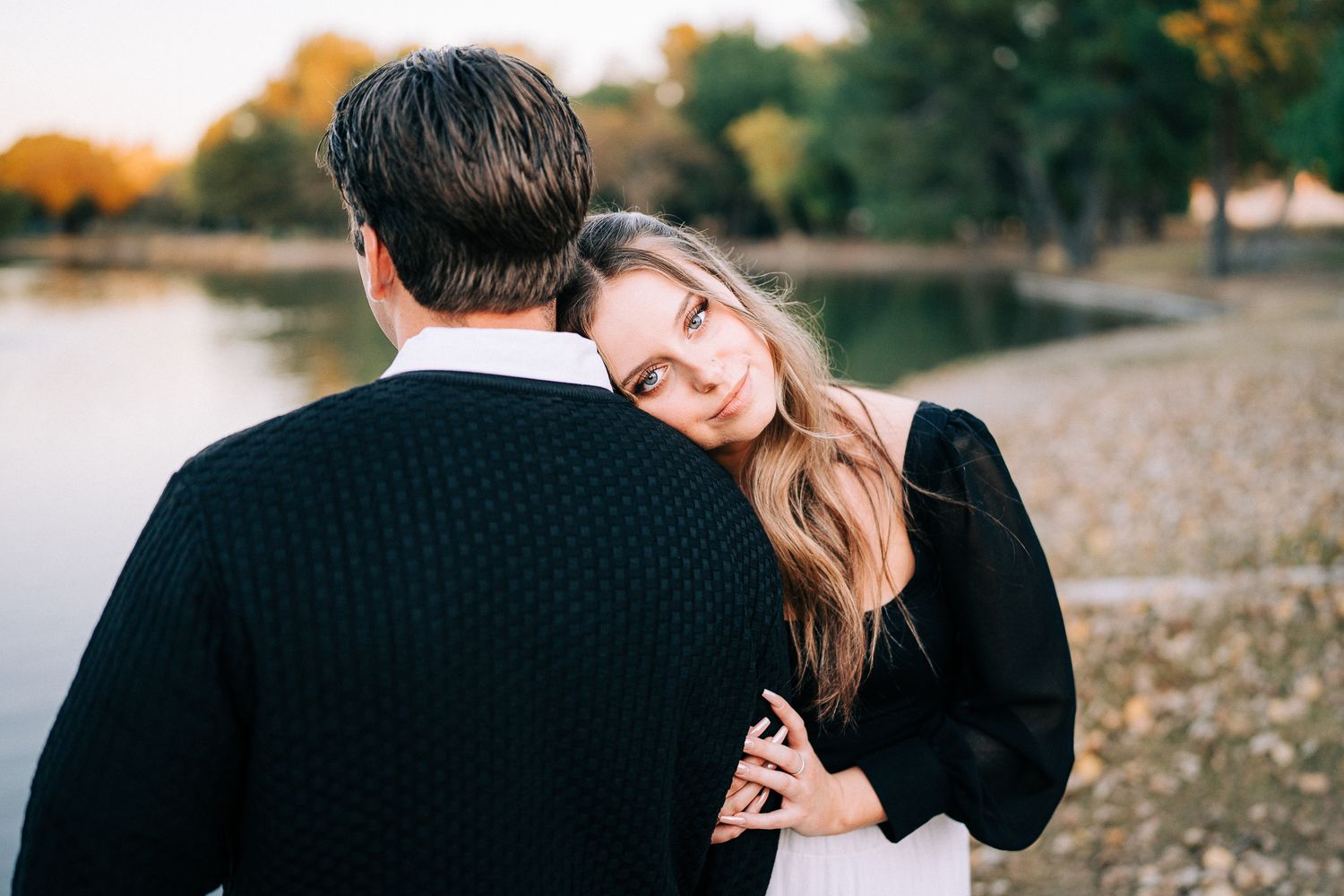 Close-up shots of couple embracing outdoors with autumn trees and water in background.