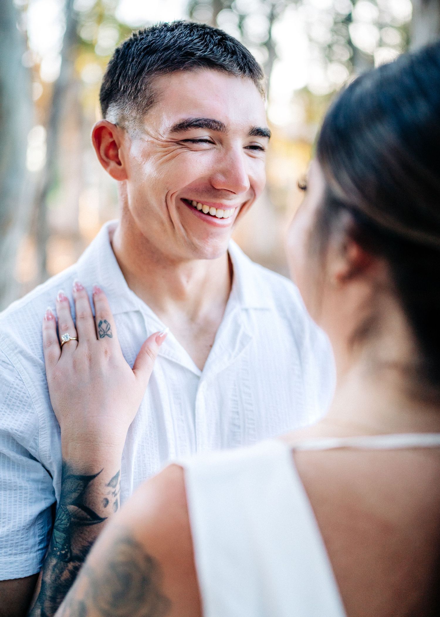 A joyful moment captured between a couple during an outdoor photoshoot in a eucalyptus grove.