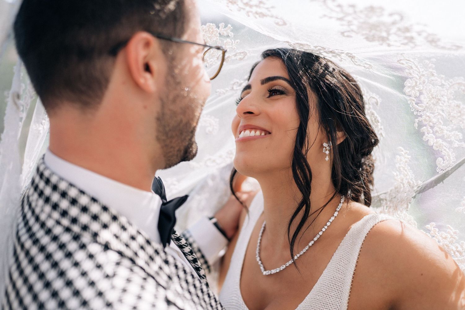 Intimate wedding moment captured under decorative arch.