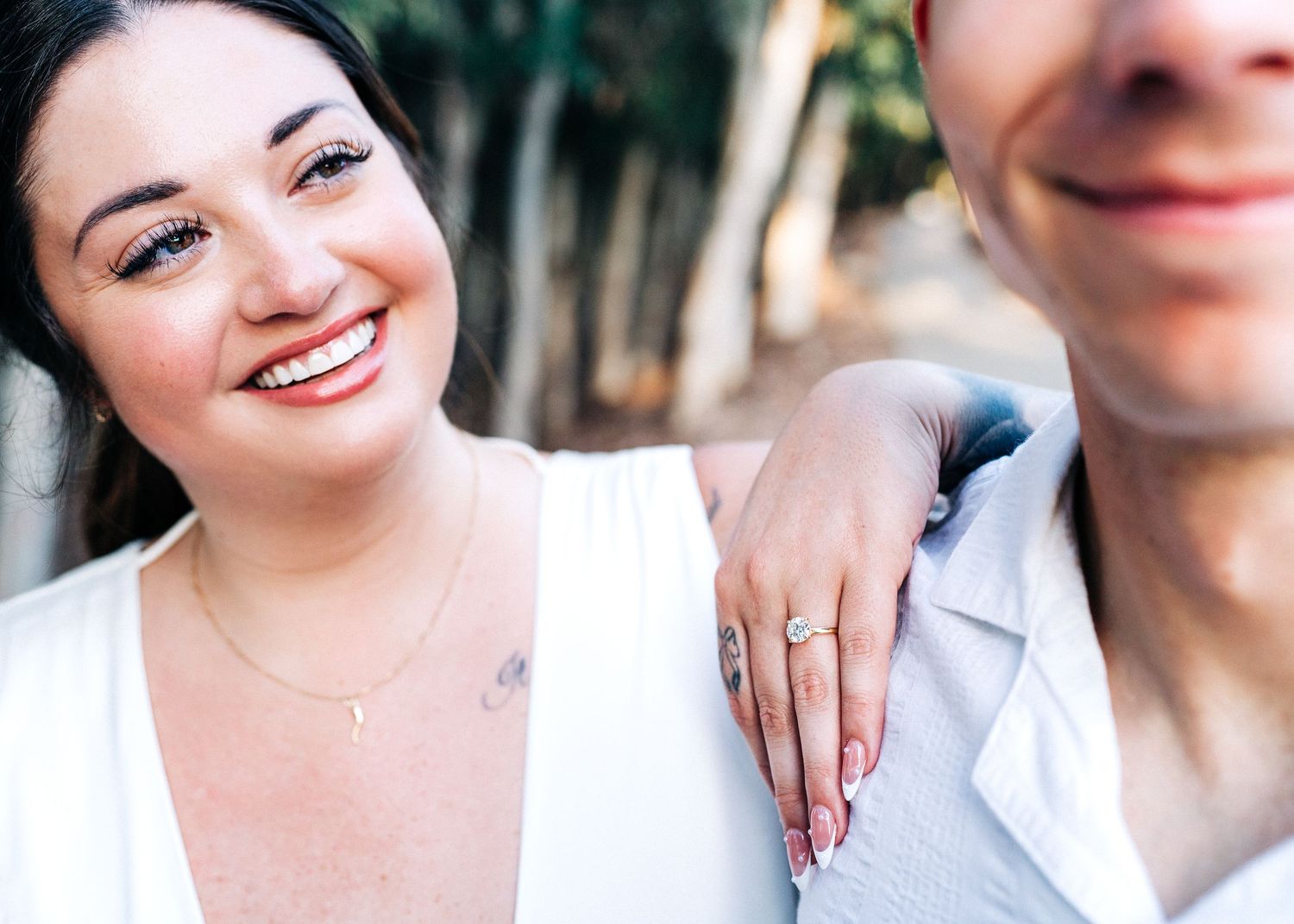 A close-up shot outdoors showing two people sharing a joyful moment together against a blurred background.