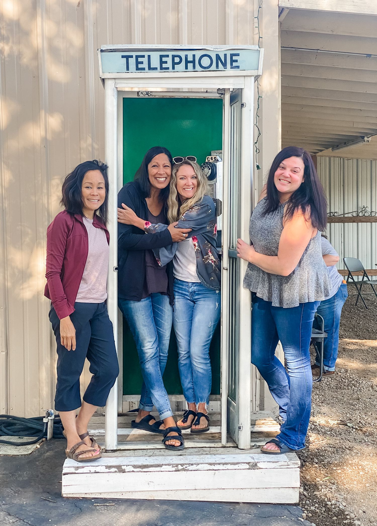 Retro telephone booth filled with people posing for a fun photo.
