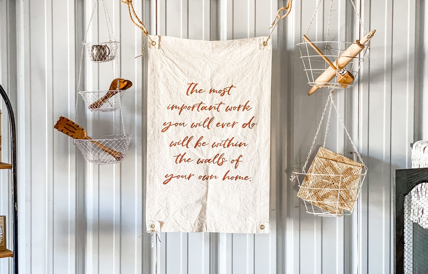 Inspirational quote banner hanging with brown vintage-style scissors on rustic white wall decor.