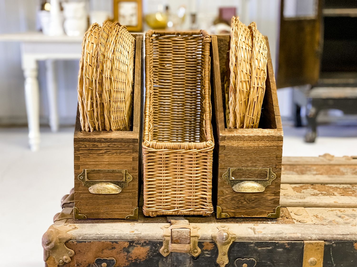 Three vintage wicker file organizers arranged on weathered wooden surface.